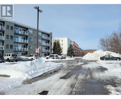 A snowy street with cars parked on the side.
