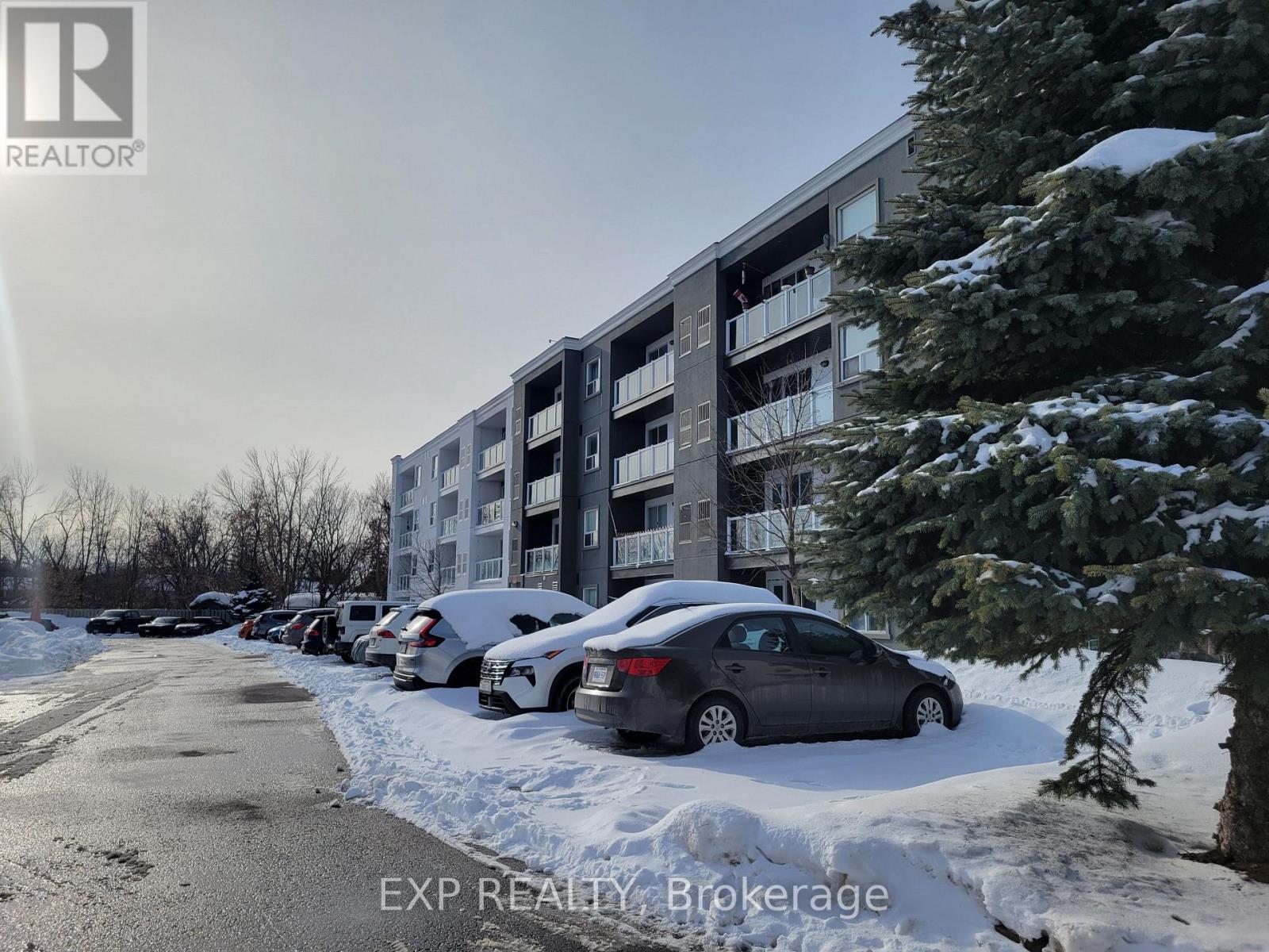 A car is parked in front of a building with snow on the ground.