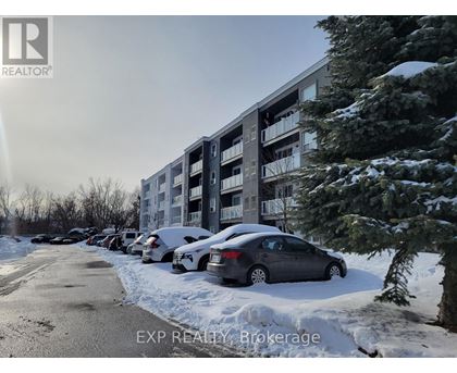 A car is parked in front of a building with snow on the ground.