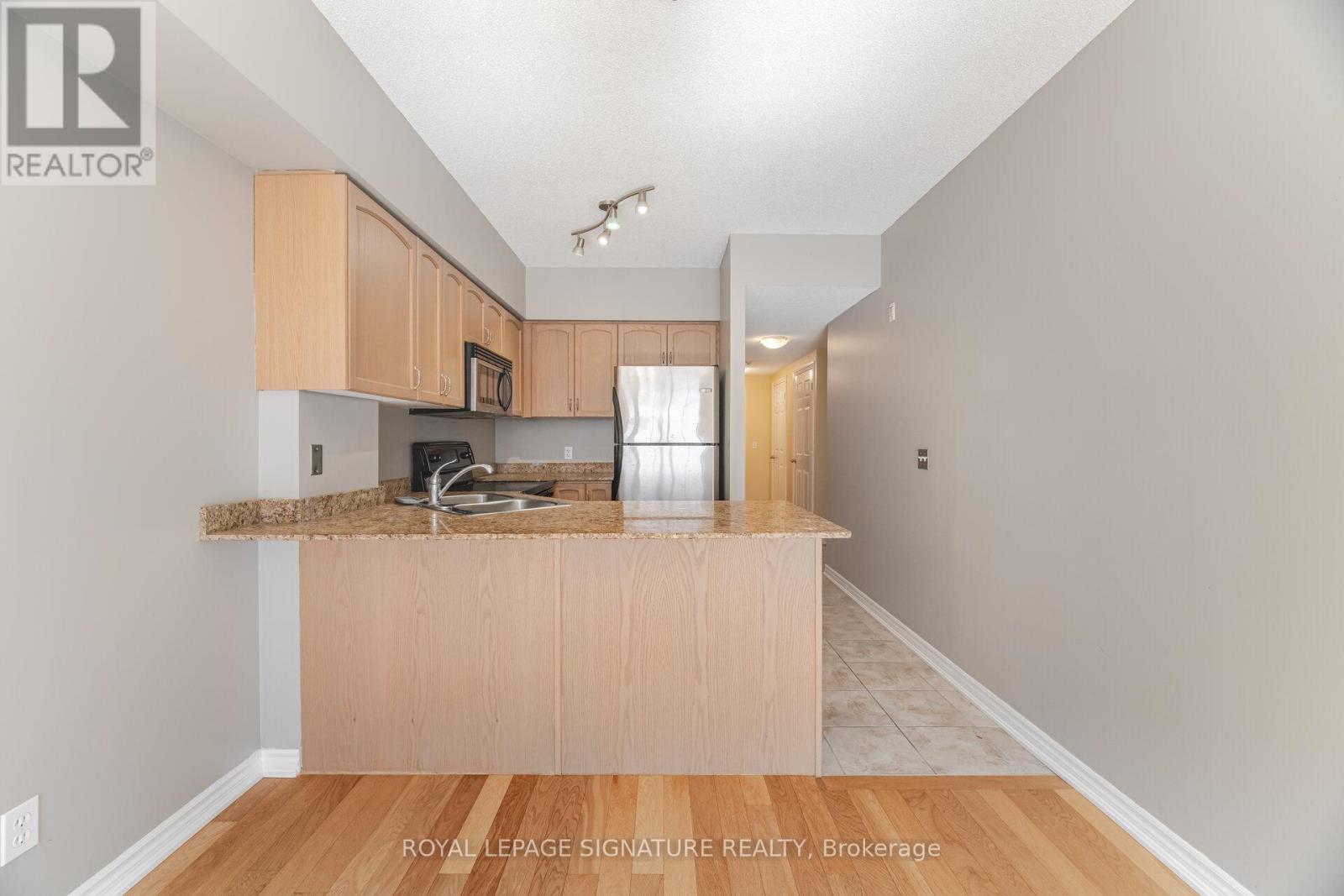 A kitchen with wooden cabinets and a granite countertop.