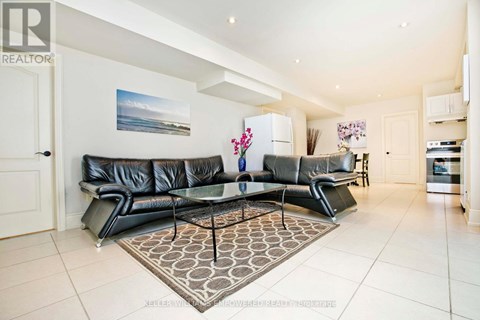 A living room with a black leather couch and a glass coffee table.