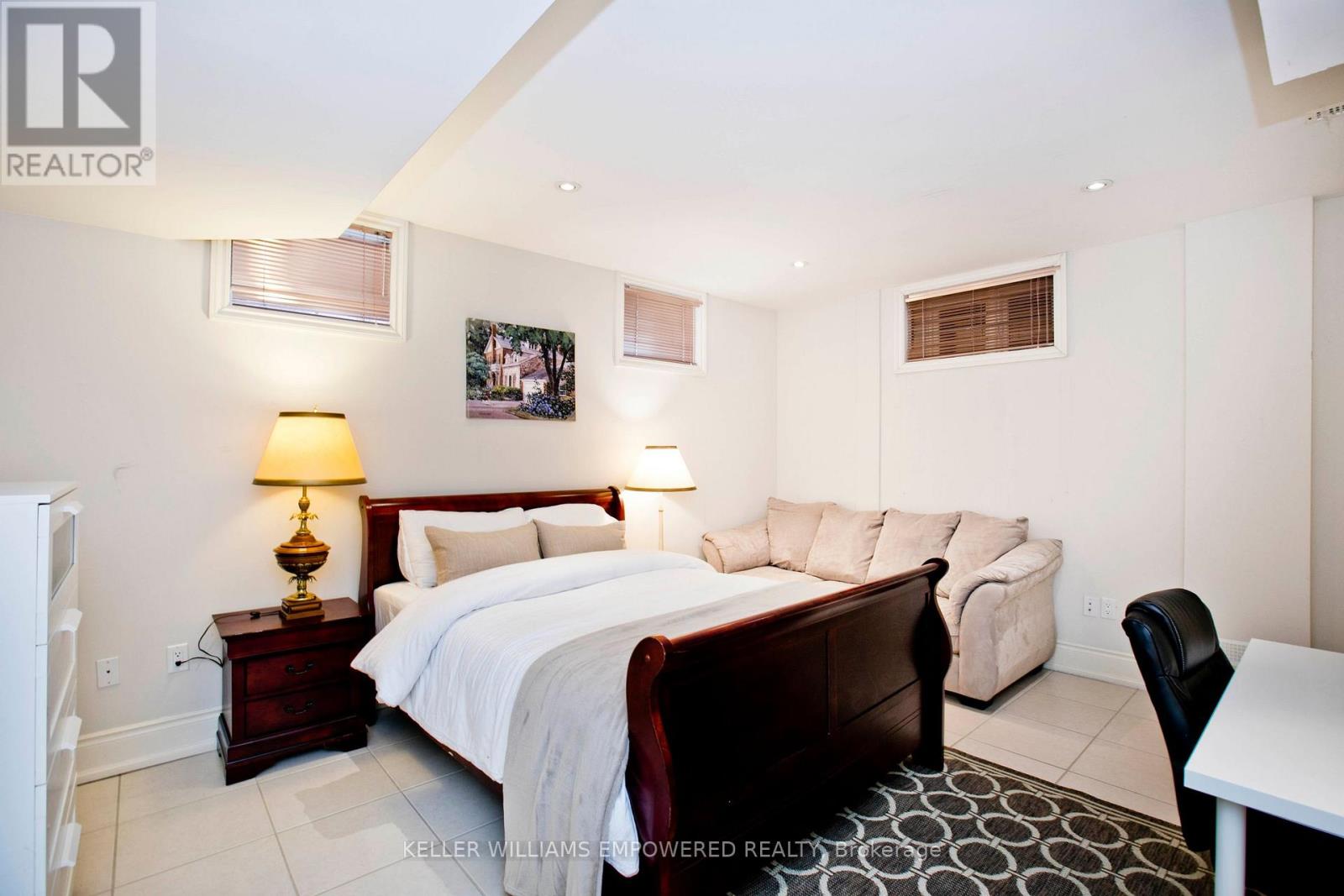 A bedroom with a large bed and a chair.