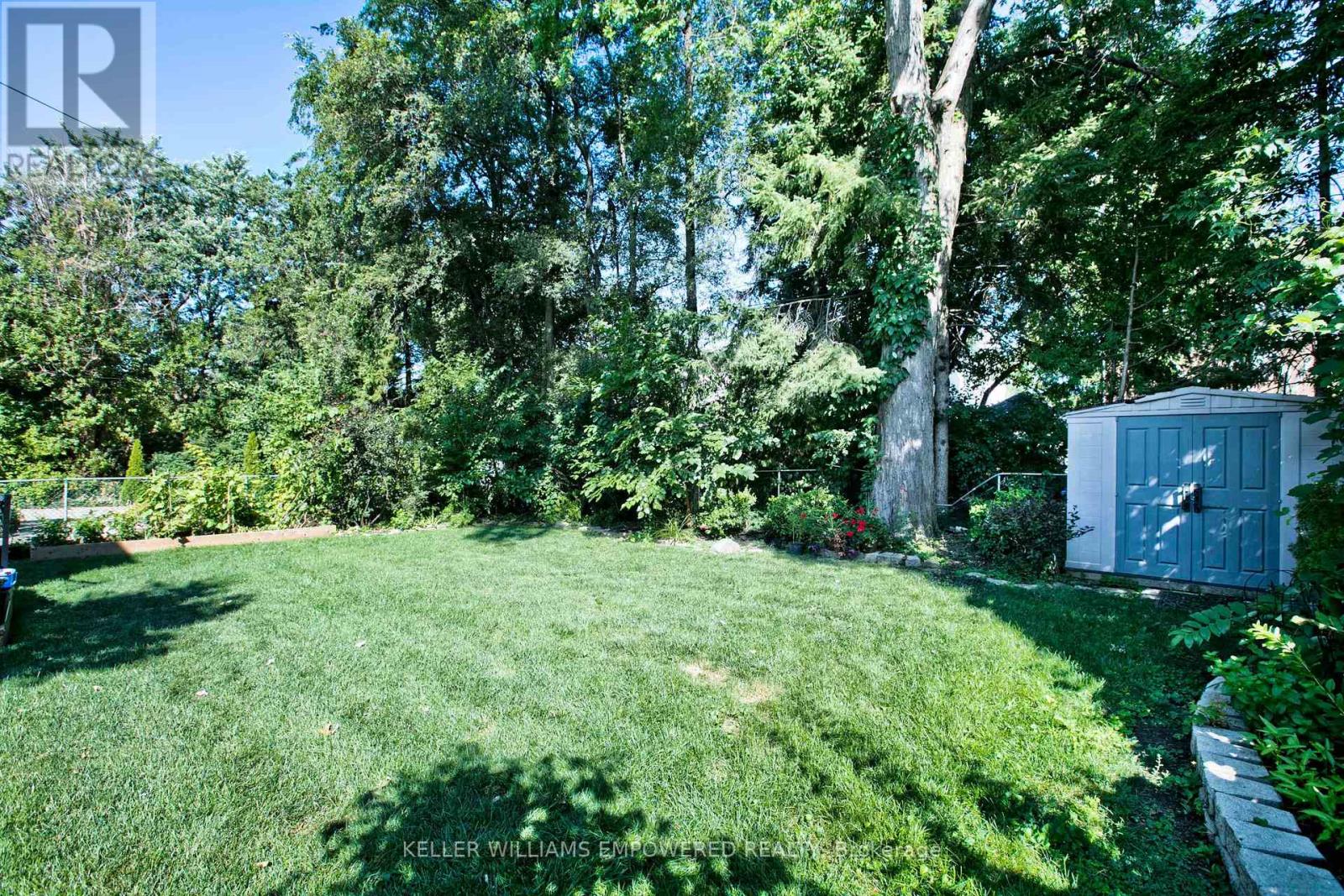 A backyard with a well-maintained lawn and trees.