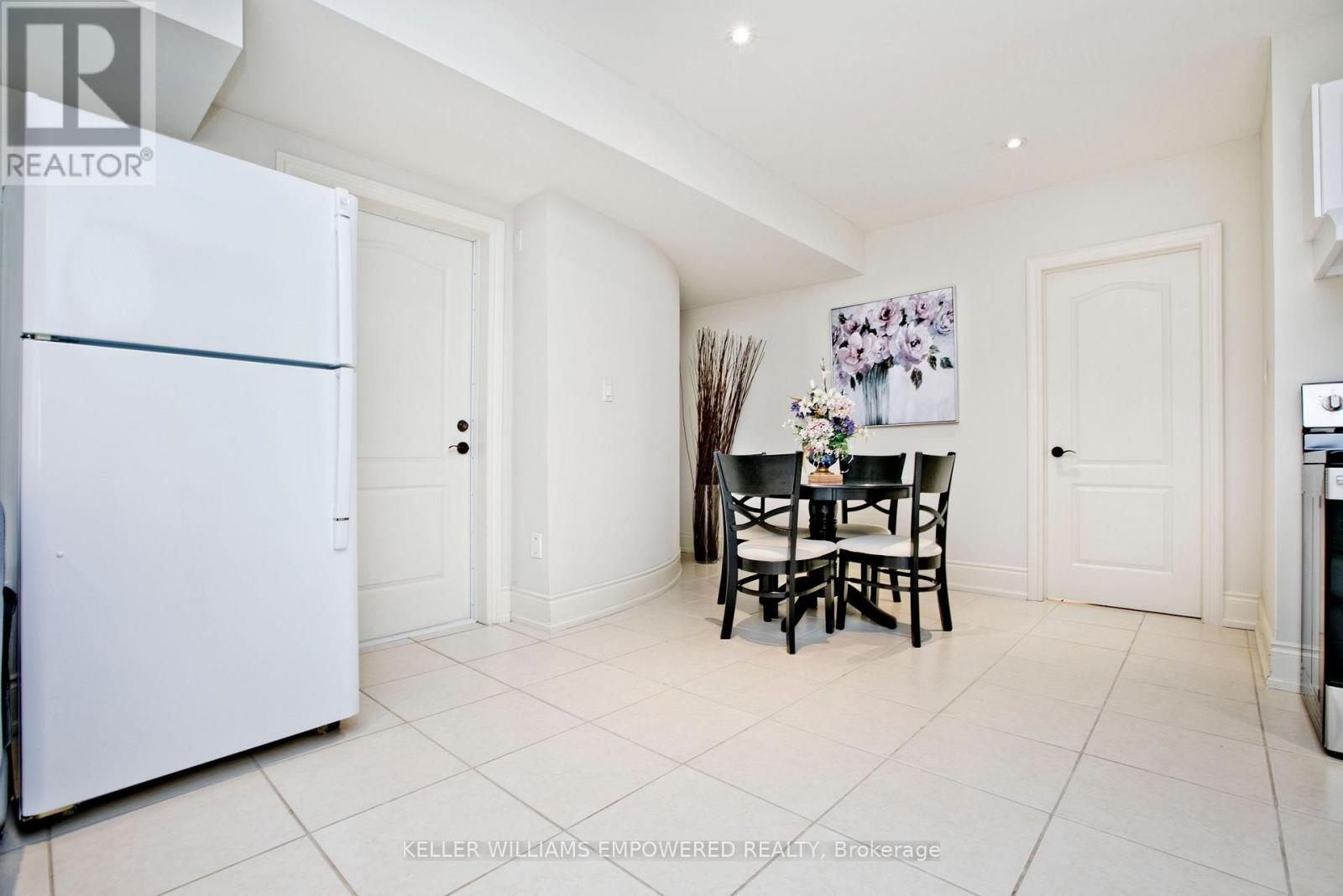 A white fridge in a kitchen with a table and chairs.