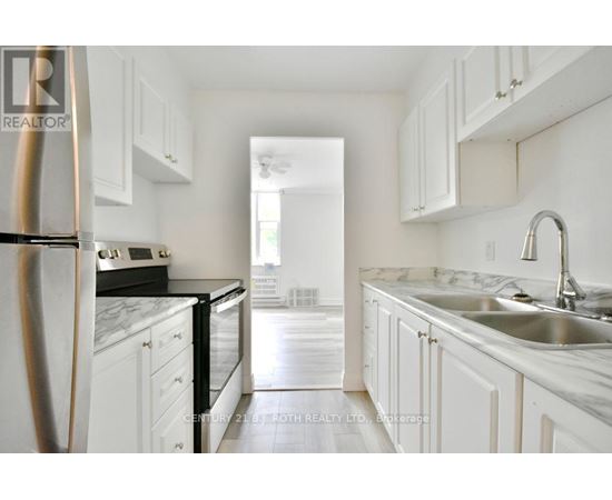 A kitchen with white cabinets and a marble countertop.