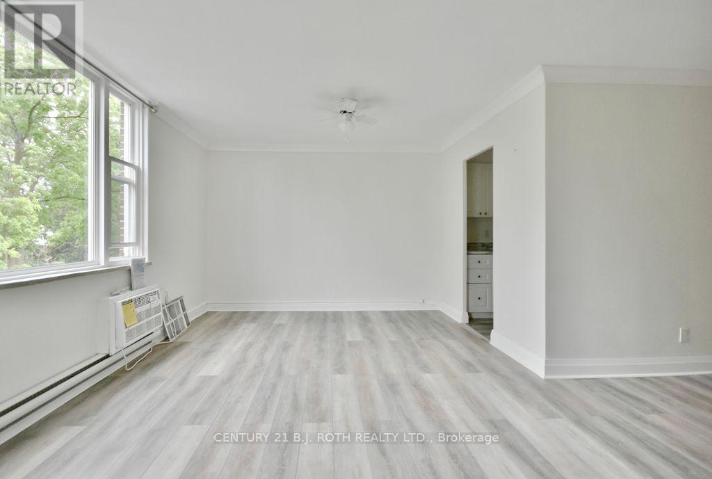 A spacious room with a window and a door leading to another room.