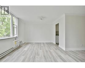 A spacious room with a window and a door leading to another room.