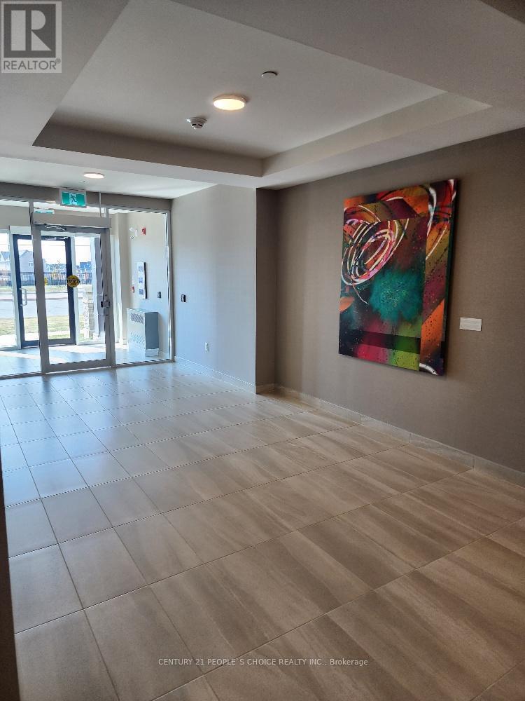 A hallway with a large painting on the wall and a glass door at the end.