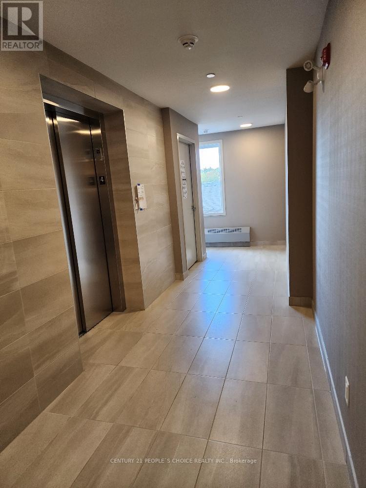A hallway with a tiled floor and a wall-mounted elevator.