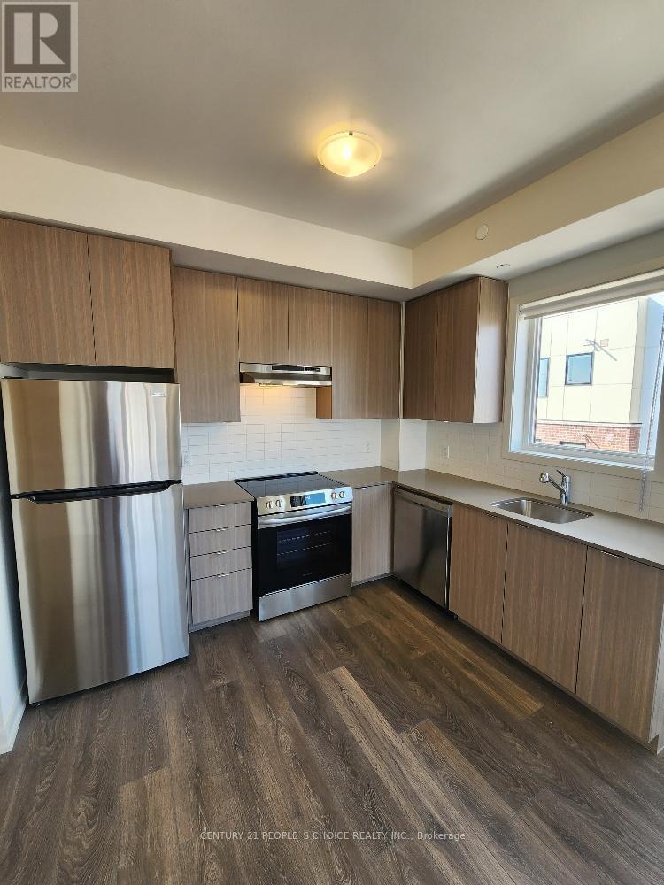 A kitchen with wooden cabinets and a stainless steel refrigerator.