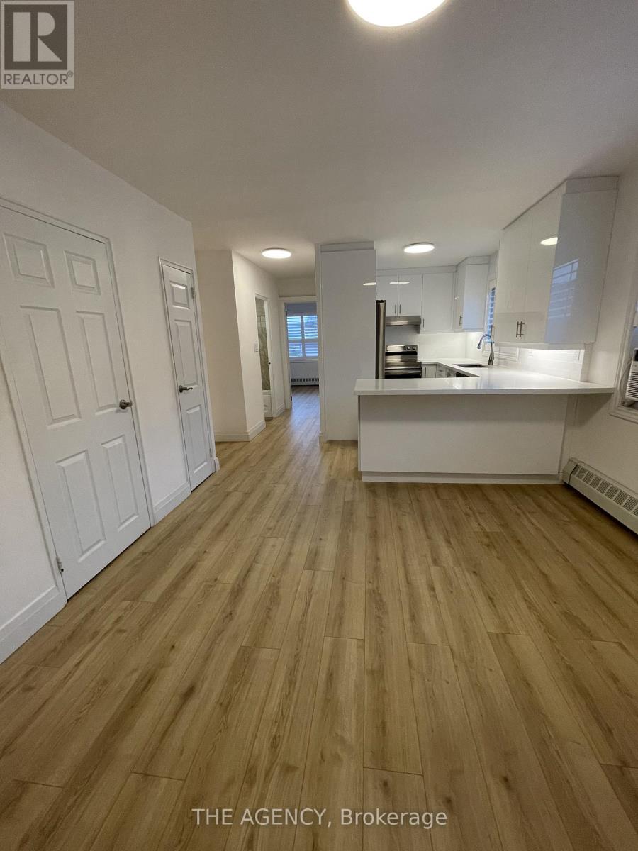 A well-lit kitchen with wooden floors and white walls.