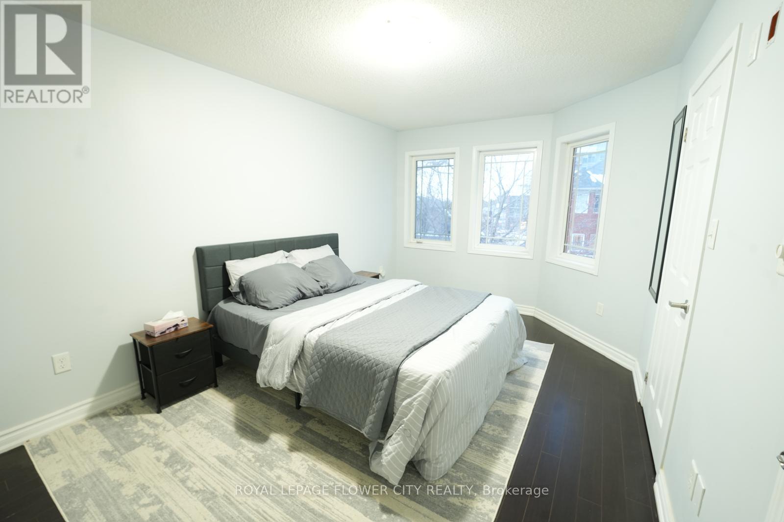 A bedroom with a large bed and a nightstand.