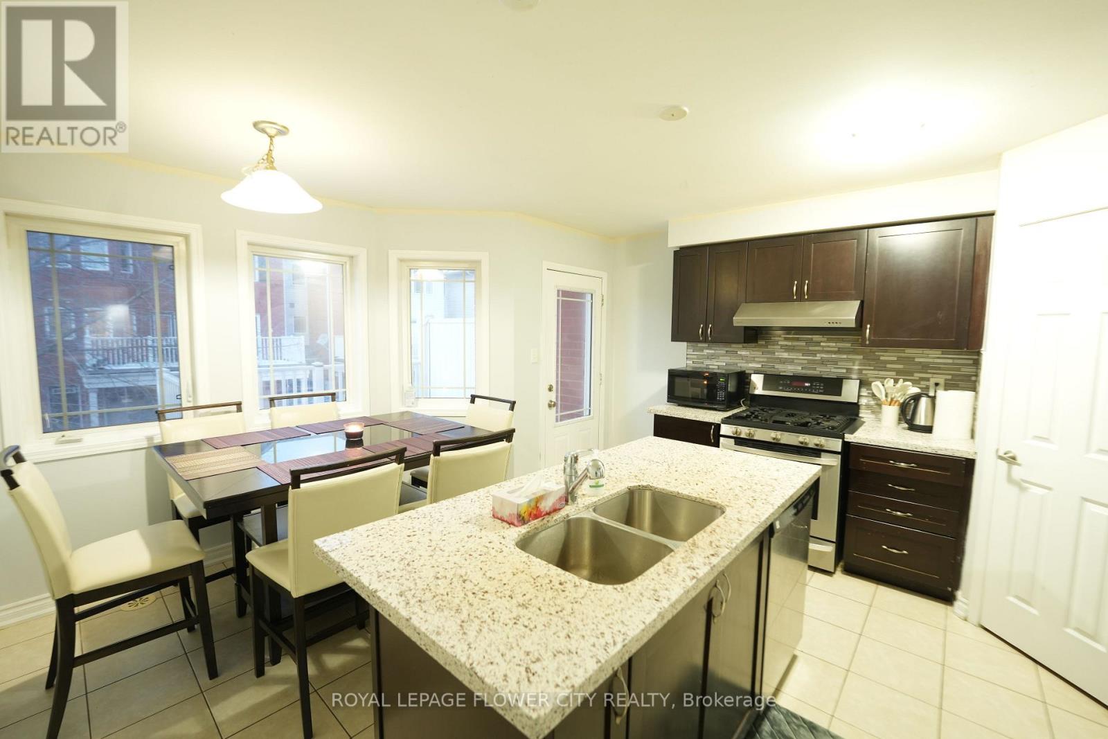 A kitchen with a table and chairs in front of a window.