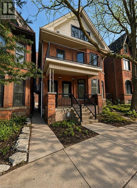 A house with a brown brick facade and a white porch.