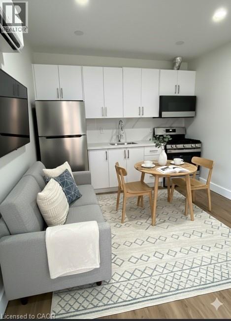 A modern kitchen with a grey couch and a dining table set for two.