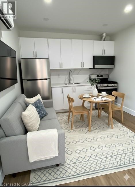 A modern kitchen with a grey couch and a dining table set for two.