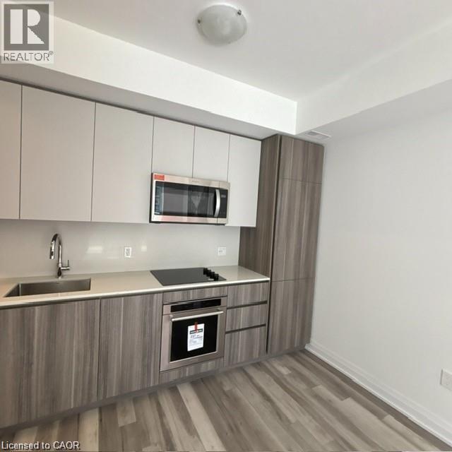 A kitchen with a microwave oven built into the cabinetry.