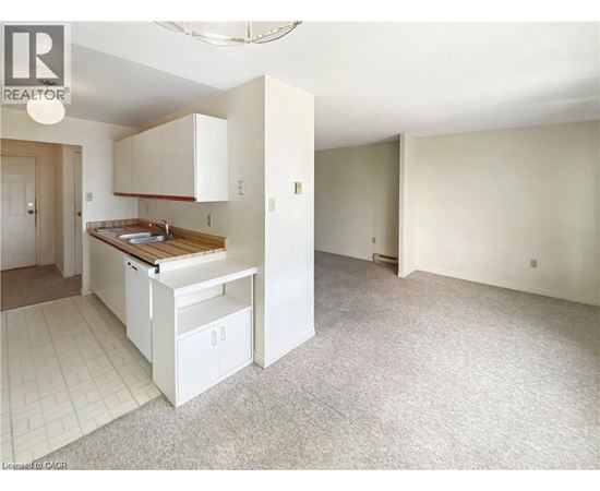 A kitchen with white cabinets and a wooden countertop.
