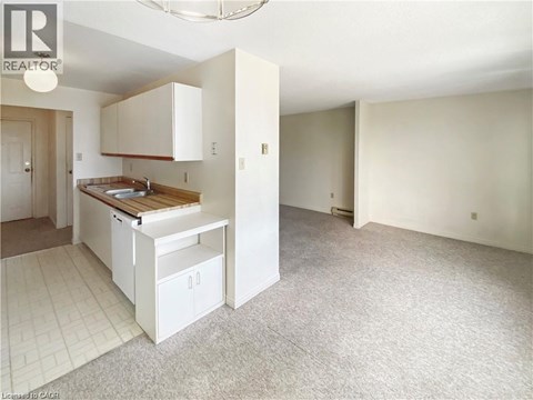 A kitchen with white cabinets and a wooden countertop.