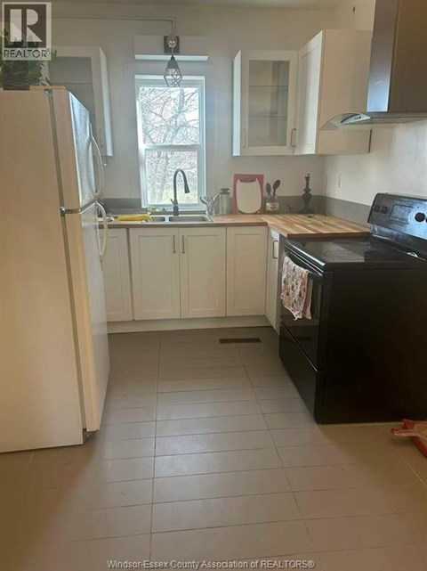 A kitchen with white appliances and white cabinets.