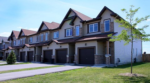 A row of houses with garages and driveways.