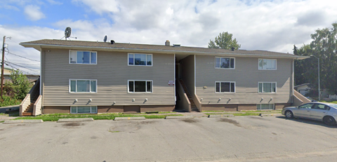 A two-story house with a car parked in front.