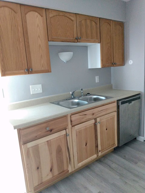 A kitchen with wooden cabinets and a white countertop.