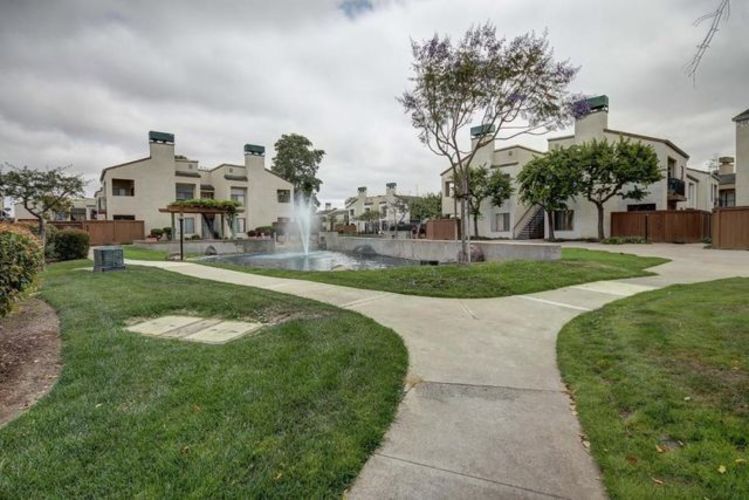 A residential area with houses and a fountain in the middle.