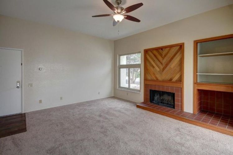 A room with a fireplace and a ceiling fan.