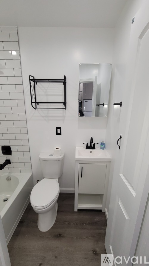 A white toilet sits next to a sink in a small bathroom.