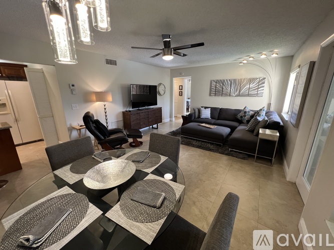 A modern dining room with a glass table and chairs.