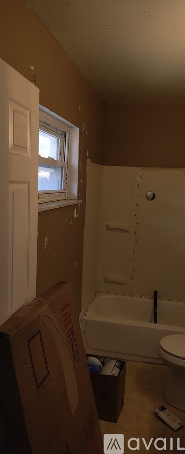 A room with a tub and a window is being remodeled.
