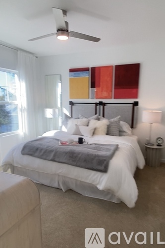 A bedroom with a large bed and a ceiling fan.
