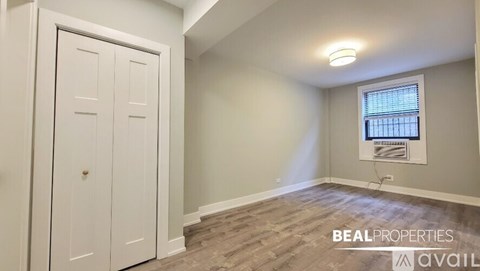A room with a white door and a window with blinds.