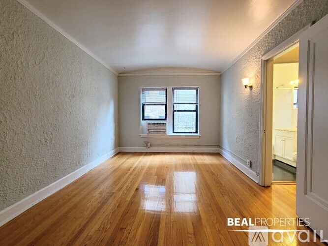 A room with wooden floors and a window is available for rent.