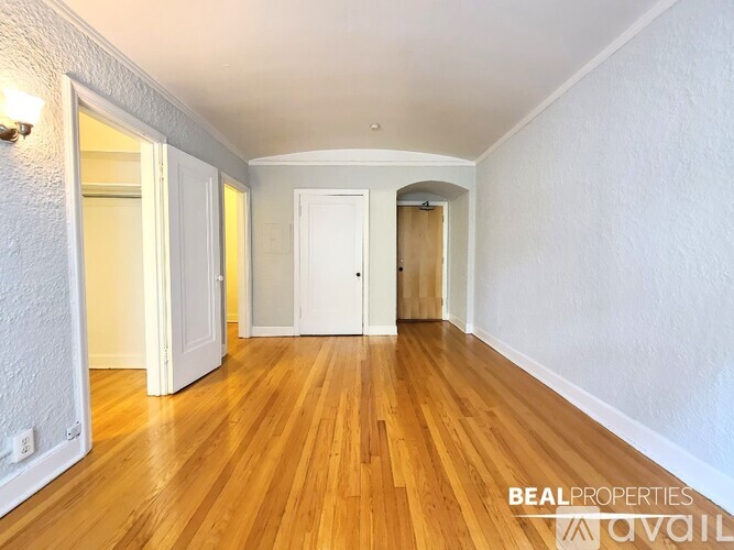 A long hallway with wooden floors and white walls.