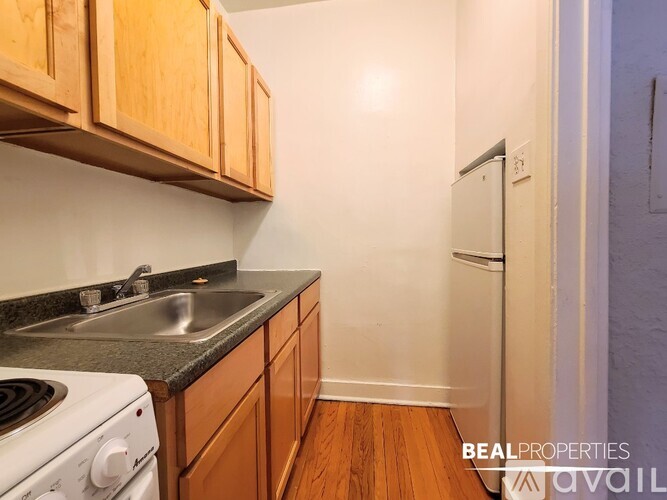 A kitchen with wooden cabinets and a white stove.