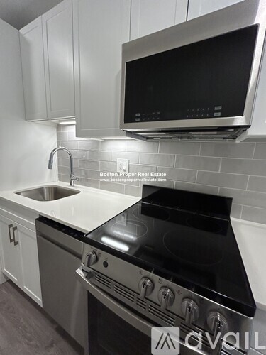 A modern kitchen with a stove top oven and a microwave above it.