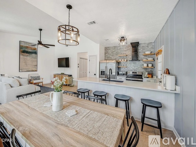 A kitchen with a bar area and a dining table with chairs.