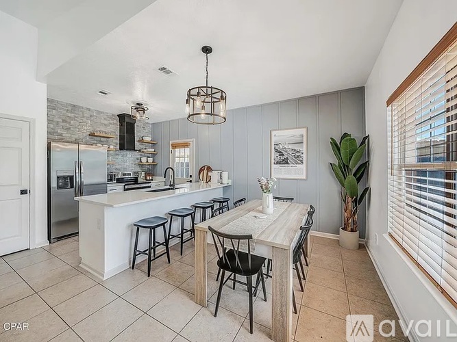 A kitchen with a table and chairs in front of a refrigerator.