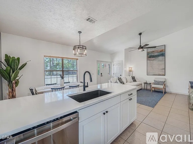 A kitchen with white cabinets and a black sink.
