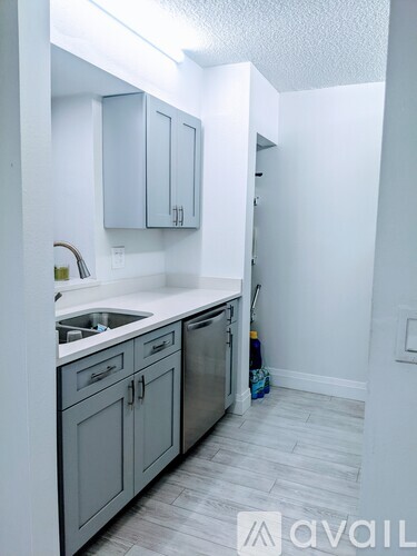 A kitchen with white cabinets and a sink.