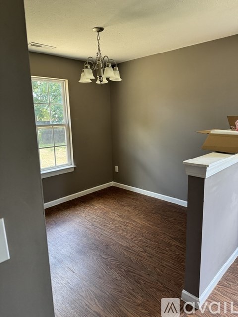 A room with a chandelier and a box on the floor.