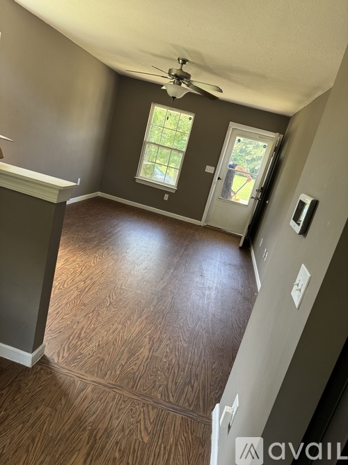 A room with a ceiling fan and a door leading to a balcony.