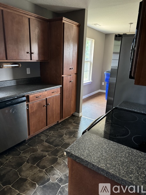 A kitchen with wooden cabinets and a black stove top oven.