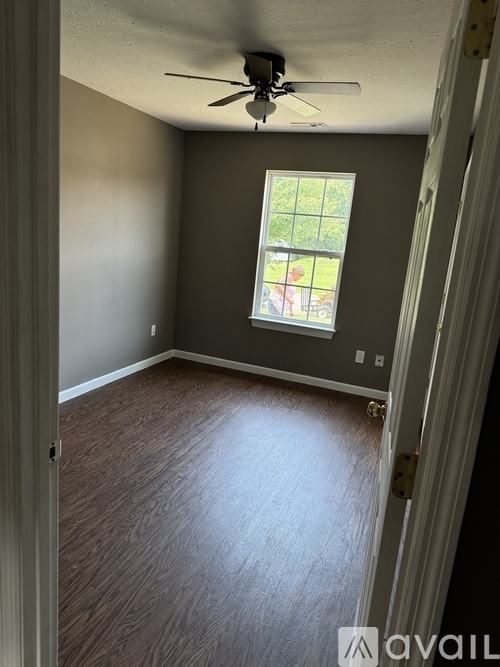A room with a ceiling fan and a window.