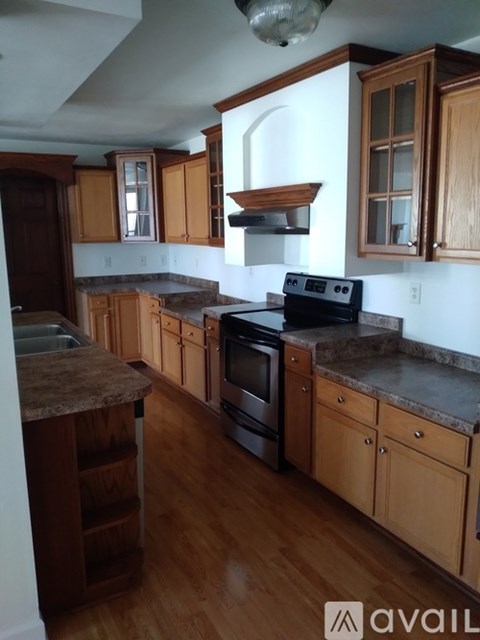 A kitchen with wooden cabinets and a black stove top oven.