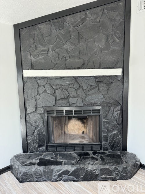 A stone fireplace with a wood burning fire inside.