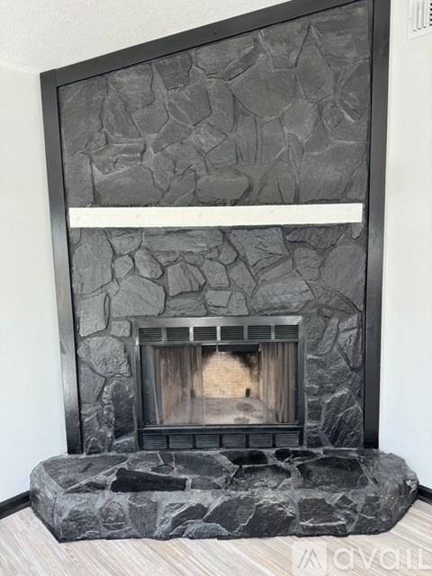 A stone fireplace with a wood burning fire inside.