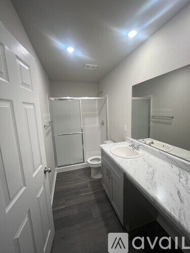 A bathroom with a marble countertop and a walk-in shower.